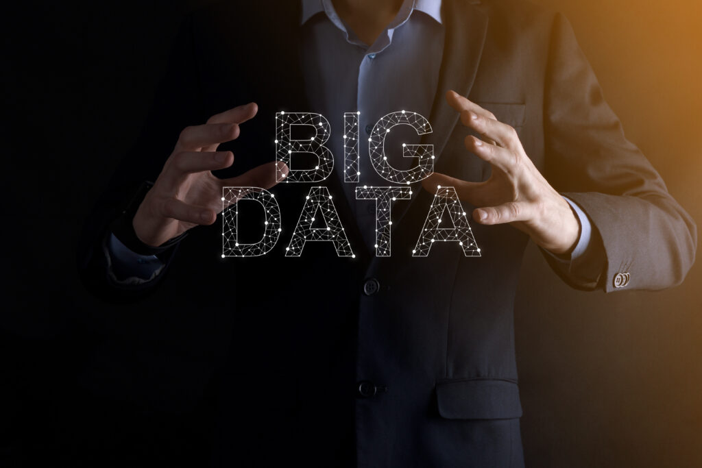businessman in a suit on a dark background holds the inscription big data. storage network online server concept.social network or business analytics representation
