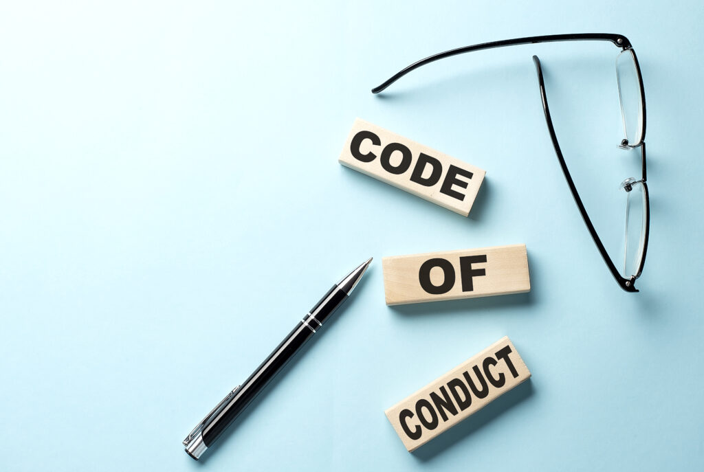 text code of conduct concept on wooden block on the blue background